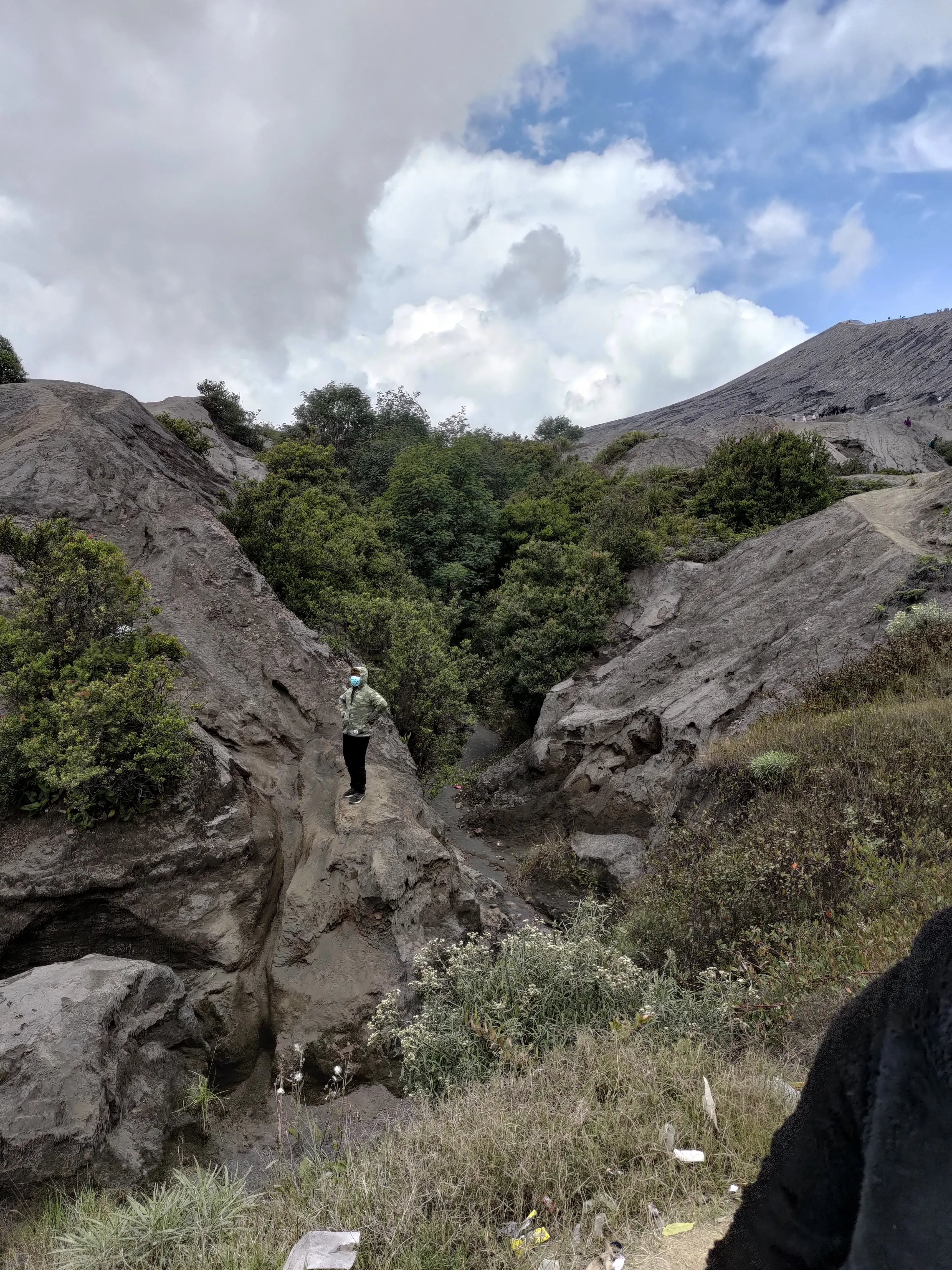 Someone standing on top of a giant volcano lava rock